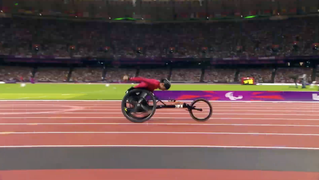 A paralympian speeds across a track